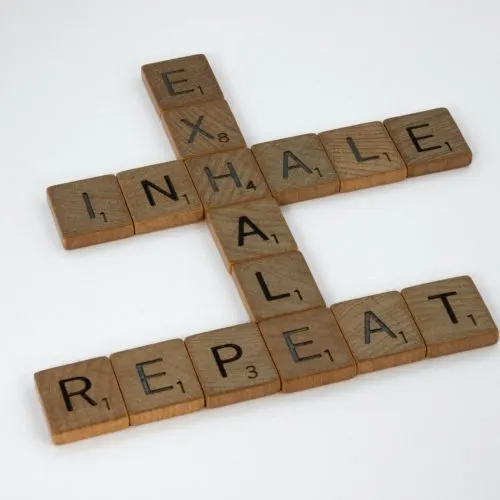 Scrabble tiles spelling “inhale, exhale, repeat” — a breathing and stress-relief motif
