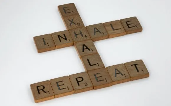 Scrabble tiles spelling “inhale, exhale, repeat” — a breathing and stress-relief motif